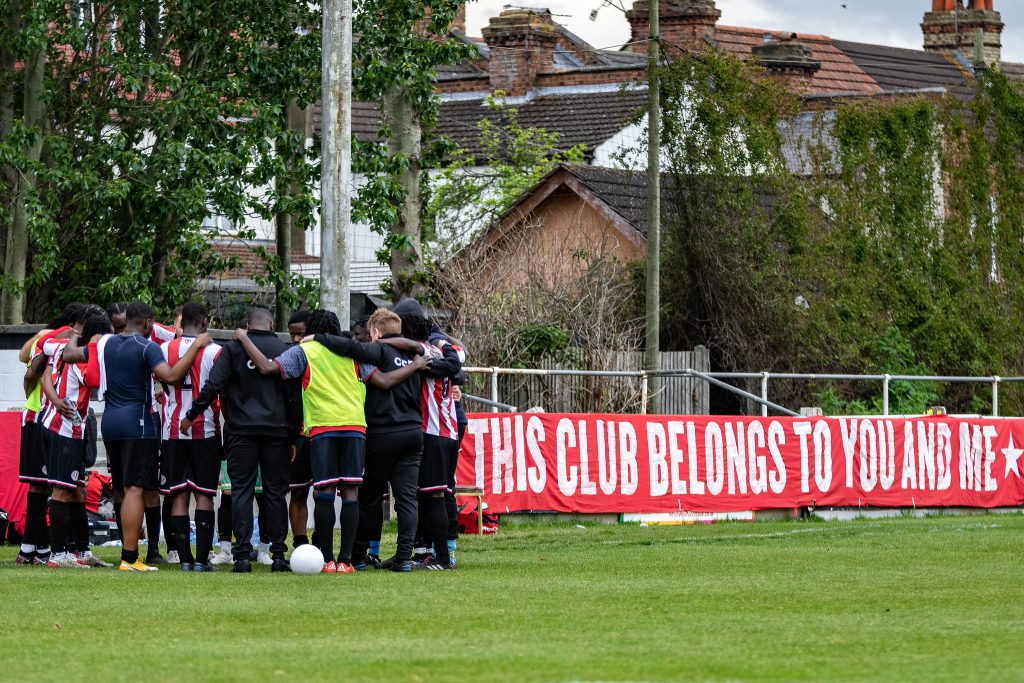 Clapton CFC men's team players in a huddle