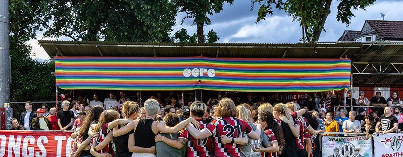 Women's first team players huddle in front of a banner in the stand that says CCFC